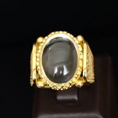 Capture a beautiful moment with this 18K yellow gold plated sterling silver crystal quartz ring. Handmade with natural Durr Al Najaf gemstone, this unique jewelry is a daring addition to your collection. Size 10, but can be resized. Metal: 925k Sterling Silver (18k gold plated) Gemstone: Crystal Quartz also known as Durr al-Najaf Dimensions of the stone: 15x20mm Size: US 10 Durr Al Najaf is a glossy and clear gemstone from the quartz family. The name means "pearl of Najaf" as it can only be sour Luxury Gold Moonstone Ring, Elegant Gold Moonstone Cabochon Ring, Luxury Yellow Gold Crystal Ring With Gemstone, Elegant Gold Crystal Ring With Cabochon, Luxury Moonstone Cabochon Ring As Gift, Luxury Gold Oval Moonstone Ring, Elegant Gold Hallmarked Moonstone Ring, Luxury Cabochon Moonstone Ring Gift, Elegant Gold Moonstone Ring Hallmarked