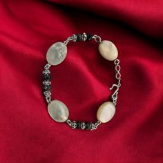 This bracelet features stunning Mother of Pearl and faceted onyx beads accented with intricate Silver Bali beads. It measures 7 inches in length. Elegant Onyx Beaded Bracelets With Natural Stones, Elegant Oval Agate Beads And Cabochons, Elegant Oval Bead Agate Jewelry, Elegant Handmade Bracelets With Oval Beads, Elegant Onyx Bracelets With Faceted Beads, Elegant Onyx Bracelet With Faceted Beads, Elegant Agate Jewelry With Oval Beads, Elegant Beaded Agate Crystal Bracelet, Elegant Agate Oval Beads