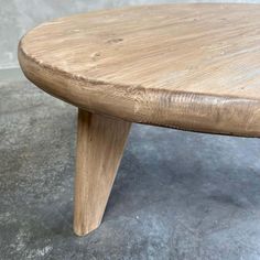 a wooden bench sitting on top of a cement floor