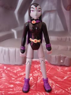 an action figure is posed on a red surface