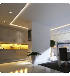 a modern kitchen with white walls and flooring is lit by recessed lighting above the countertop