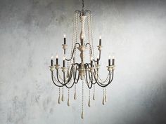 a chandelier hanging from the ceiling in a room with concrete walls and flooring