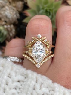 a woman's hand with a gold and white diamond ring on top of her finger