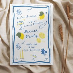 a birthday party card with lemons and wine glasses on it next to some dry grass