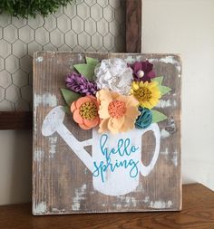 a wooden sign that says hello spring with flowers on it