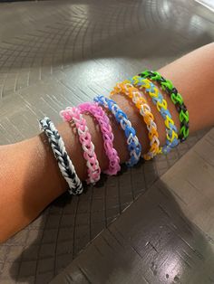 four different colored bracelets on someone's arm