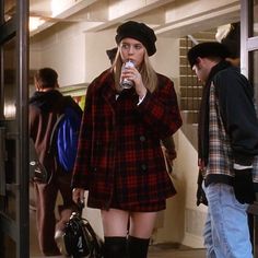 a woman in short shorts and boots drinking from a cup