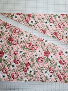 two pieces of quilted fabric with flowers on them next to a ruler and measuring tape