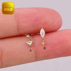 a person's finger with two different types of earrings on it and the other side has