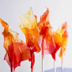 colorful lollipops are sitting on top of a blue table with white walls in the background