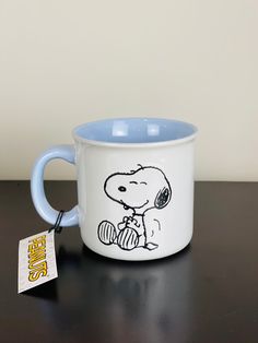 a blue and white coffee mug with a cartoon character on the side sitting on a table