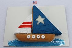 a cake shaped like a sailboat with stars and stripes on the side, sitting on top of a card