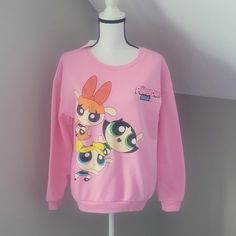 a pink sweater with cartoon characters on it sitting on a mannequin's head