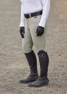 a woman in riding gear is posing for the camera with her horse boots and gloves on