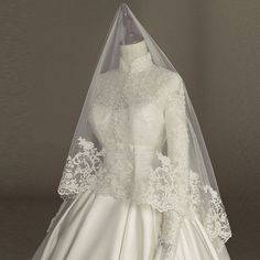 a white wedding dress with lace on the top and sleeves, is shown in front of a mannequin