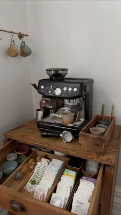 an espresso machine sitting on top of a wooden table next to other items