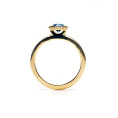 a yellow gold ring with a blue diamond on top