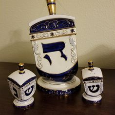 a white and blue vase sitting on top of a wooden table next to two salt and pepper shakers