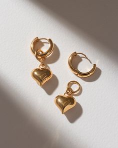 We've taken our iconic heart pendant up a notch by turning it into a removable charm, paired with our classic gold huggies. Wear the earrings with the charms for a sweet and effortless look, or slide them off when you want a more minimalist style. Either way, this is a classic staple you'll wear again and again! Hoop Heart Charm Jewelry For Everyday, Everyday Heart Charm Huggie Earrings, Gold Huggie Earrings With Dangling Charms For Everyday, Everyday Gold Huggie Earrings With Dangling Charms, Everyday Tarnish Resistant Heart Earrings, Everyday Hoop Earrings With Heart Charm, Everyday Dangle Huggie Earrings For Valentine's Day, Everyday Small Hoop Huggie Earrings With Heart Charm, Everyday Small Hoop Earrings With Heart Charm