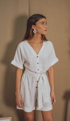 OUR GAELLE LINEN JUMPSUIT IS ELEGANT AND COMFY AT THE SAME TIME. YOU CAN WEAR IT  LOOSE OR CINCHED AT THE WAIST. BUTTONED FRONT, WIDE PATTERN AND SIDE POCKETS.THE PERFECT PIECE FOR ALL YOUR SUMMER WANDERINGS! BLUE ANEMONE IS A SUSTAINABLE, ETHICAL AND ARTISANAL BRAND, ALL OUR STYLES ARE HANDMADE USING THE BEST SUSTAINABLE MATERIALS LIKE LINEN, COTTON,HEMP AND RAMIE. ALL OUR ORDERS ARE CUSTOM MADE TO AVOID GENERATING OVERSTOCKS AND MORE WASTE TO OUR BELOVED PLANET ALL OUR CLOTHES ARE ETHICALLY PR Chic Linen Jumpsuits And Rompers With Short Sleeves, Chic Linen Jumpsuits And Rompers With Tie Waist, Spring Linen V-neck Jumpsuit, Spring Linen Jumpsuit With V-neck, Linen V-neck Jumpsuits And Rompers For Spring, Chic Linen Jumpsuits And Rompers For Day Out, Relaxed Fit Linen Jumpsuit With V-neck, White Linen Summer Dress For Work, White Linen Beach Jumpsuits And Rompers