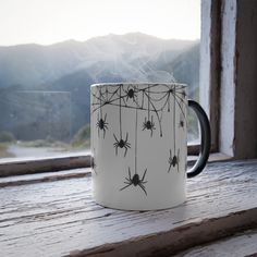 a coffee mug with spider webs hanging from it