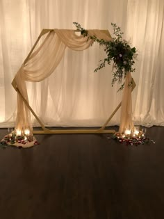 a wedding arch decorated with greenery and candles