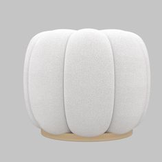 three white round cushions sitting on top of a wooden stand in front of a gray background