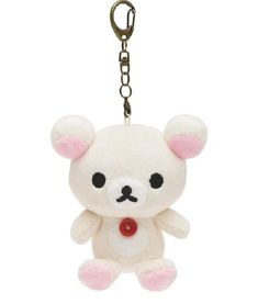 a white teddy bear keychain with black eyes and pink ears, hanging from a metal hook