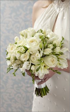 a bride holding a bouquet of white flowers