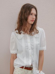 This is a casual and comfortable blouse that is made out of high quality cotton and rayon blend fabric. With design detail of embroidered lace detail on the collar and sleeve, it gives a trendy and casual look. - Rose label detail- Voluminous silhouette with shirring on shoulder and sleeve- Embroidered lace detail on collar and sleeve Casual Blouse With Lace Collar And Short Sleeves, Casual Short Sleeve Blouse With Lace Collar, Casual White Blouse With Boho Collar, Summer Cotton Blouse With Doll Collar, Casual Blouse With Lace Short Sleeves, Casual Short Sleeve Blouse With Lace Sleeves, Feminine Cotton Lace Top With Lace Trim, Summer Cotton Lace Top With Lace Sleeves, Casual Short Sleeve Lace Top With Lace Collar