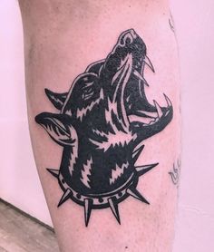 a black and white tattoo on the leg of a person with an animal head in it