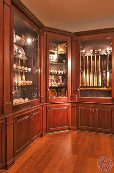 a room filled with lots of wooden cabinets and shelves covered in glass cases on top of hard wood flooring