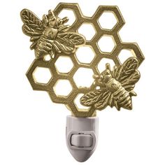 a gold honeycomb with two bees on it's side and a light switch in the middle