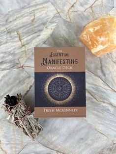 the essential manifesting oracle deck by flash mcknerly on a marble surface