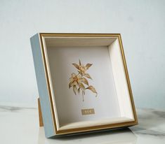 an image of a flower in a frame on a table