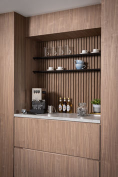 light walnut wood coffee station featuring a barista style area Wood Slat Backsplash Kitchen, Coffee Corner Ideas In Living Room, Slat Wall Kitchen, Single Wall Kitchen Design, Wood Paneling Kitchen, Wood Panel Kitchen, Wall Cupboards Design, Internal Cladding, Modern Rustic Kitchen Design