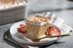 a piece of cake on a plate with strawberries and a fork next to it