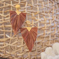 two pairs of tasseled earrings sitting on top of a basket