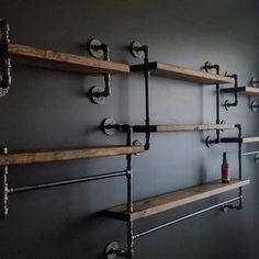 the shelves are made out of wood and have metal pipe brackets on each shelf, along with bottles