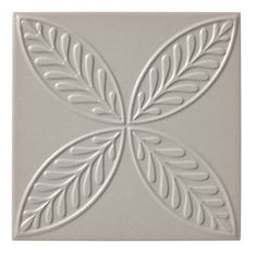 a white tile with leaves on it