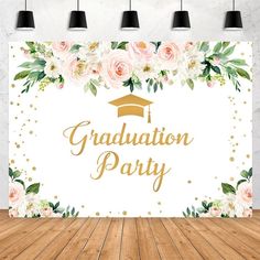 a graduation party backdrop with flowers and gold foil lettering on the front, in an empty room