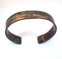 Our roman numeral bracelet is hand forged from rich jewelers bronze.  Cuffs are hammered and hand stamped with the Roman Numeral date of your choice then aged in a natural solution to give it a verdigris patina. An anniversary, child's birthday or any special date you would like to commemorate. The aging process creates a different, organic patina on each piece. No two bracelets are exactly alike. A true one of a kind just like your loveEach piece is sealed to protect it's finish. However, to pr Rustic Gold Bracelets As Gift, Rustic Gold Bracelets For Gifts, Rustic Gold Bracelet As Gift, Rustic Gold Bracelet For Gift, Stamped Bronze Bracelets As Gifts, Artisan Cuff Bracelet With Patina As Gift, Bronze Patina Bracelets As A Gift, Stamped Bronze Bracelets For Gift, Bronze Stamped Bracelet For Gift