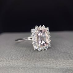 an engagement ring with a pink diamond surrounded by white diamonds