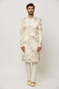 Cream sherwani with embroidered floral jaal patterns, embellished by crystals and sequin. Comes with a churidar. - Aza Fashions Wedding Sherwani With Floral Embroidery And Straight Kurta, Wedding Sherwani With Floral Embroidery In Traditional Drape, Reception Sherwani With Floral Embroidery, Wedding Sherwani With Floral Embroidery And Traditional Drape, Wedding Sherwani With Floral Embroidery, Wedding Sherwani With Mirror Work In Raw Silk, Floral Embroidered Sherwani For Wedding And Festivals, Festive Semi-stitched Sherwani With Floral Embroidery, Floral Embroidered Sherwani For Reception During Eid