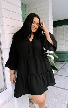 This flirty and flowy black mini dress has a tiered skirt and a tie front detail making it a boho dream! Soft ruffles along the 3/4 sleeves and bottom hem give a feminine touch. Black Flowy Dress Outfit, Plus Size Western Outfits, Flowy Dress Outfit, Western Work Outfit, Black Flowy Dress, Casual Wedding Guest Dresses, Dresses With Cowboy Boots, Dresses Western, Maternity Bridesmaid Dresses