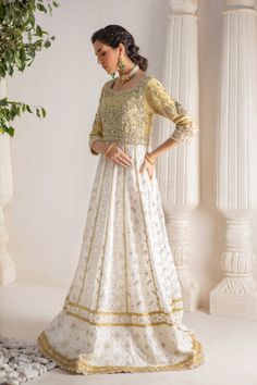 A contemporary Classic - Over a canvas of Pure chikankari chiffon, features a beautiful floral embroidered bodice further enhanced with dabka, sequins, pearls and kundan work. This classy peshwas is paired with gorgeous kamdani work dupatta, making this an absolute favorite for nikkah, engagement & other celebratory festivities Hand crafted tassels & straight pant completes the look of this outfit. Peshwas Fabric: Pure Chiffon Peshwas Length: 60” (customisable, mention in order notes) Sleeve length: 16” Pant Fabric: Khaadi Silk Dupatta Fabric: Georgette Chiffon Color: Ivory & Gold This outfit is fully lined, neck key-hole can be lined on request, mention in order notes. Please refer Size Guide Before selecting size For Customised measurements please select Custom size for an additional 20$ Kamdani Work, Kundan Work, Embroidered Bodice, Pure Chiffon, Pakistani Designers, Contemporary Classic, Silk Dupatta, Key Hole, Color Ivory