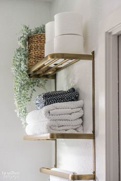 towels are stacked on shelves in the bathroom, with one folded towel and another rolled up