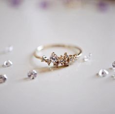 a diamond ring sitting on top of a table next to other jewels and diamonds around it