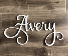 there is a wooden sign that says avery on it and the word's name in cursive font