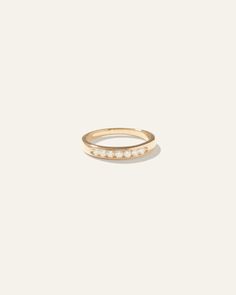 a gold ring with three small white stones on the front and side, set in 18k yellow gold